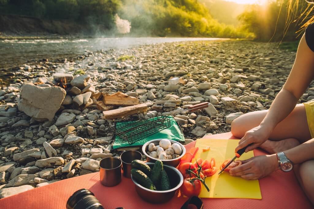 Gemüsezubereitung am Lagerfeuer mitten in der Natur – Outdoor-Küche am Fluss