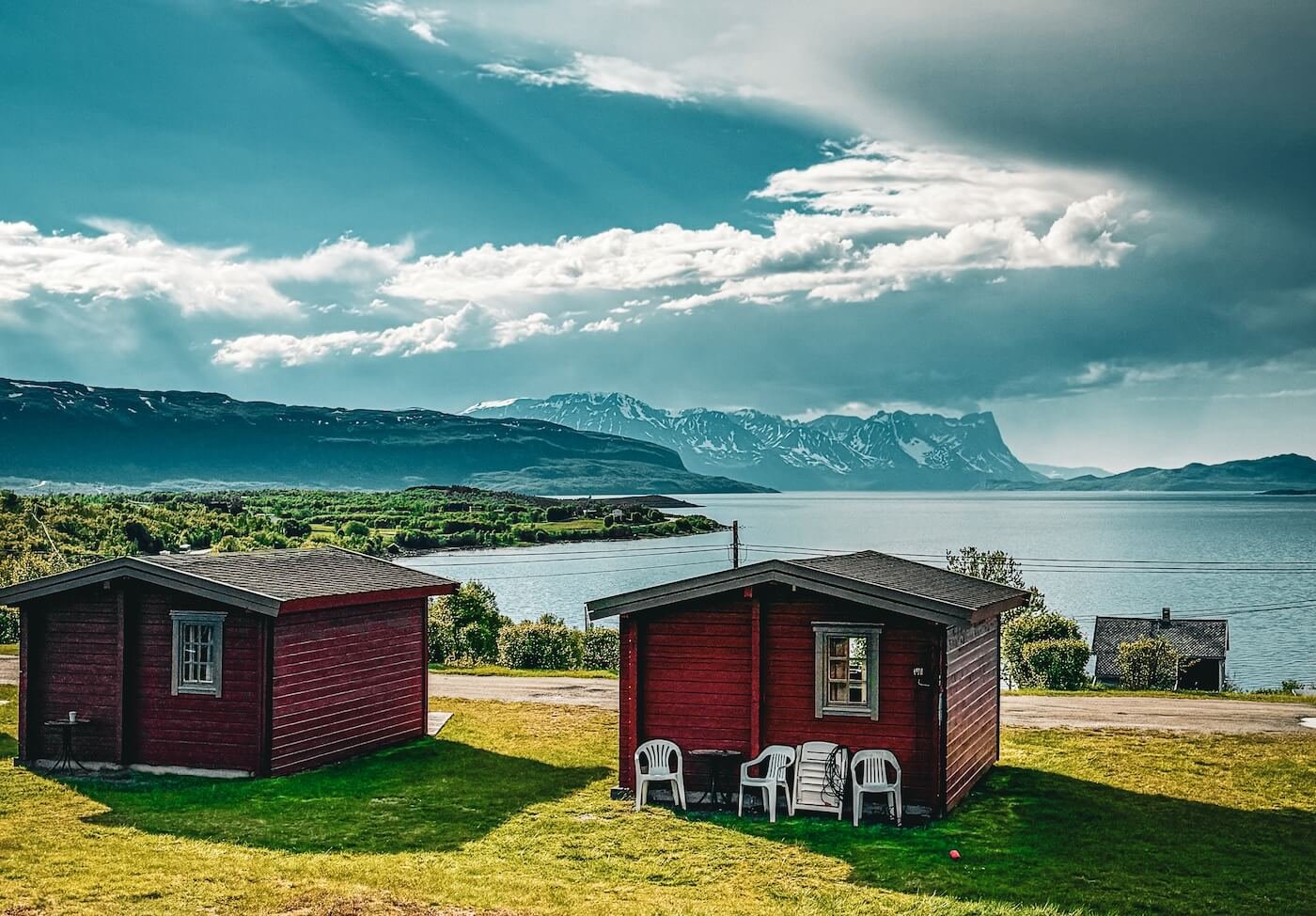 Zwei rote Hütten am Fjord in Nordnorwegen mit Blick auf die Berge – perfekter Ort für Camping mit Thermacell Backpacker und Mückenschutz für Camping