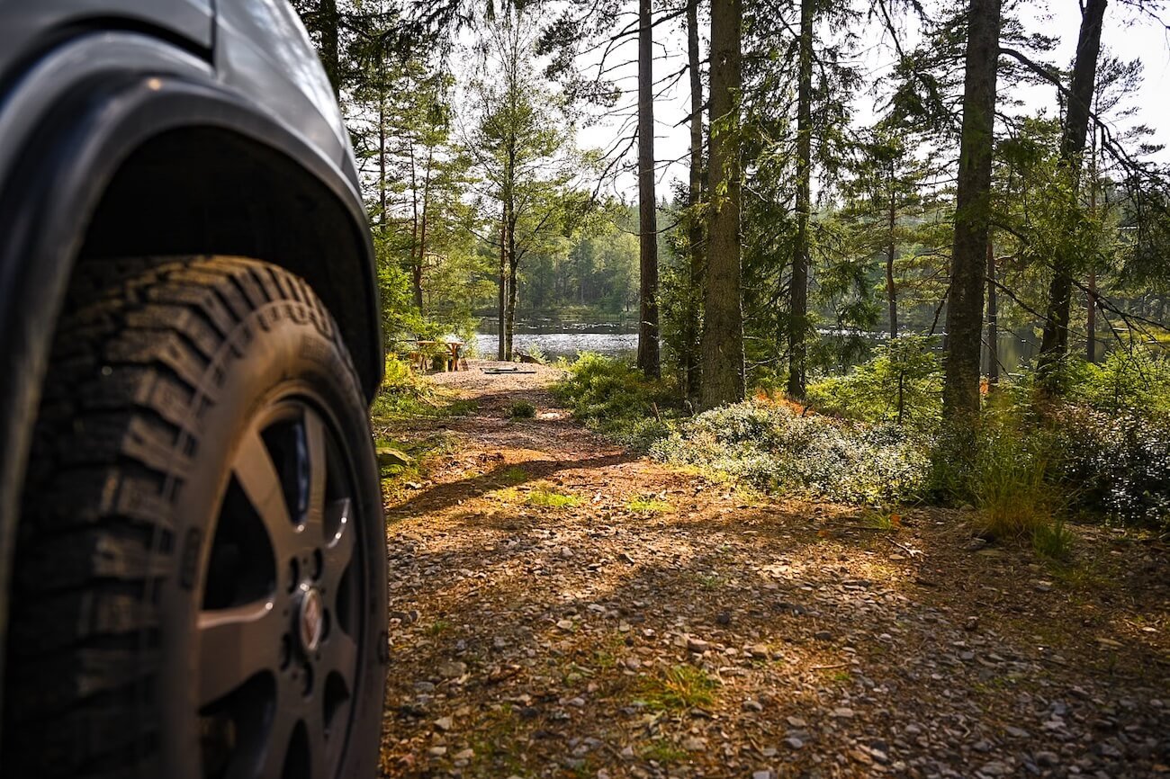 Autarkes Campen mit dem Campervan in der Natur: Stellplatz im Wald mit Blick auf einen See – Off-Grid-Freiheit
